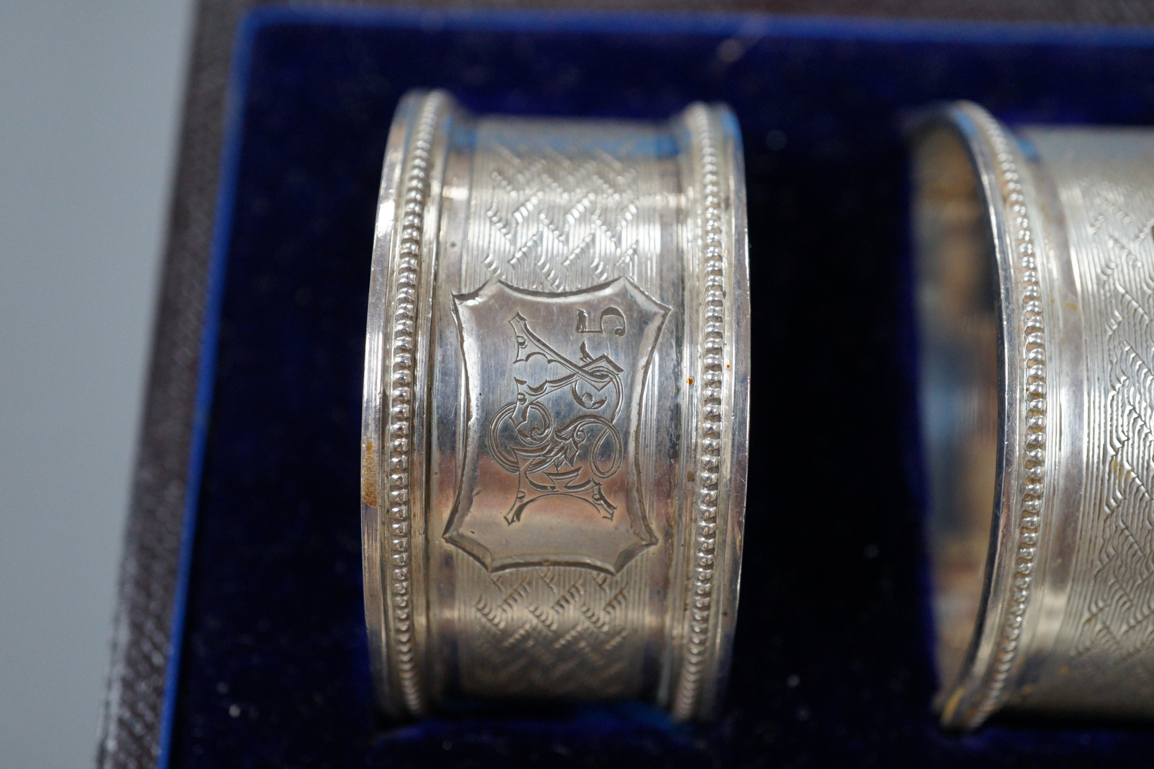 A cased set of six Victorian engraved silver napkin rings, Atkin Brothers, Sheffield, 1876.